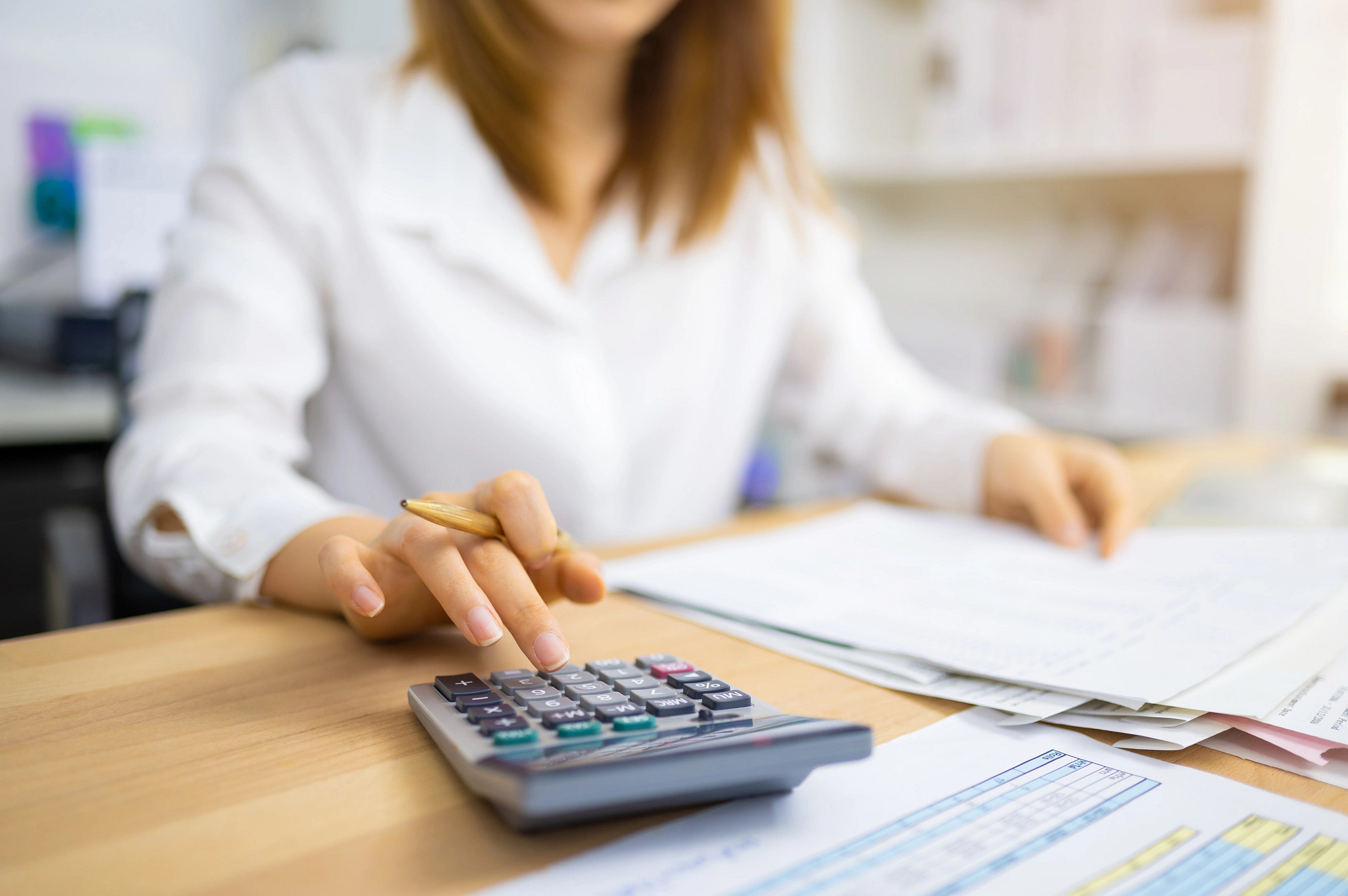 a woman doing paperwork using a calculator