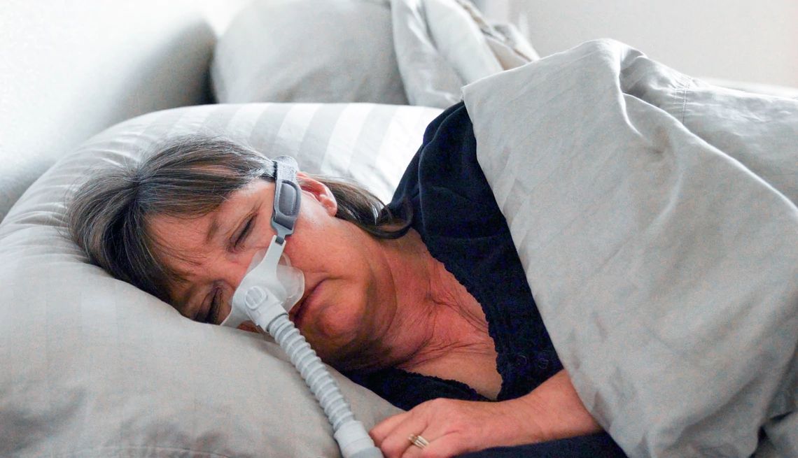 Una mujer duerme con una máquina CPAP