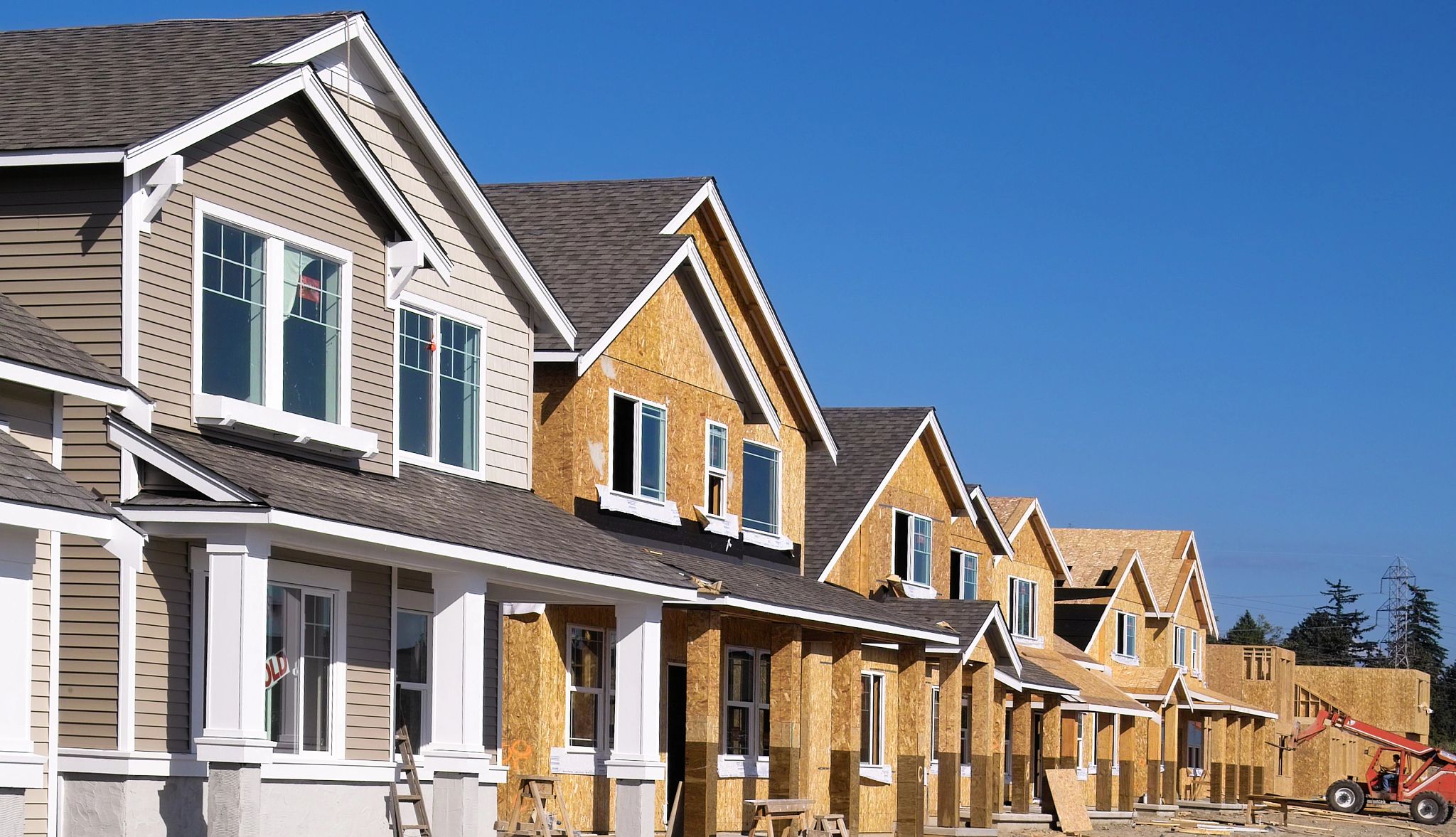 What to look for before buying new home Row of houses, some built with siding on, others without siding, some still being built