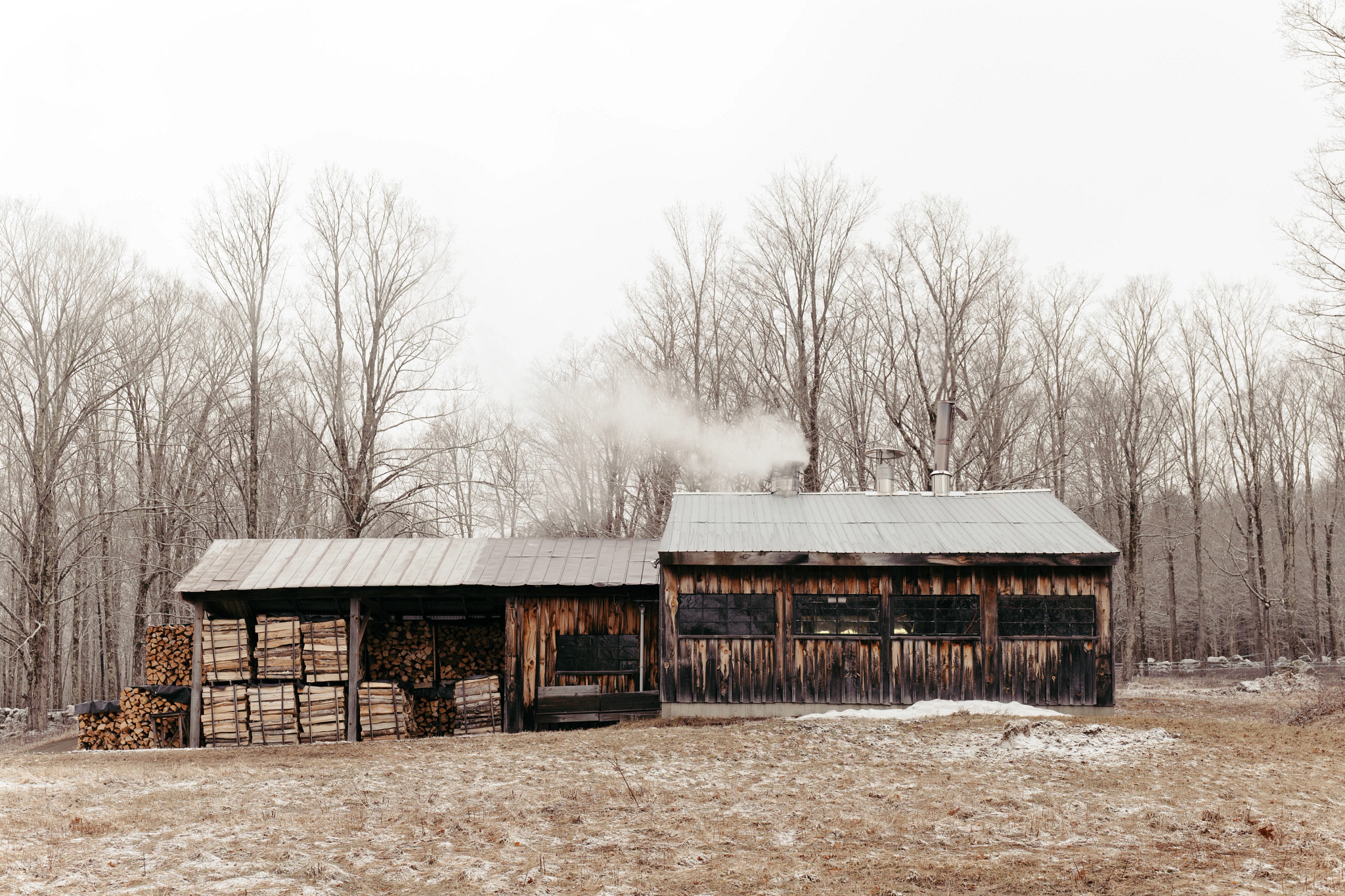 a photo shows smoke rising from the maple syrup evaporator inside the sugar shack at Tomapo Farm