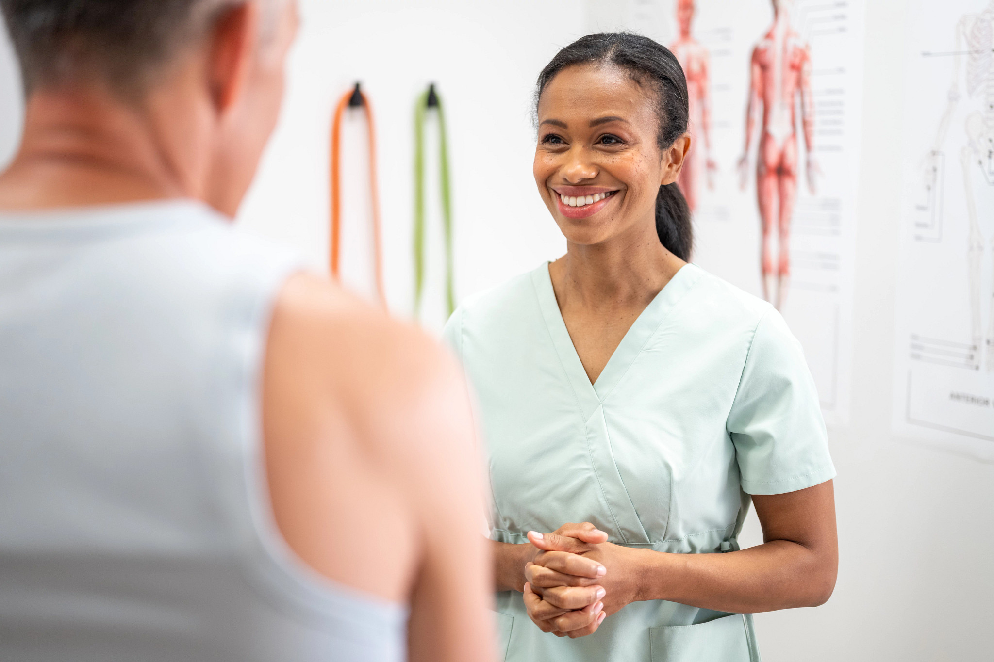 Physical therapist talking with a patient during a consultation in a brightly lit clinic