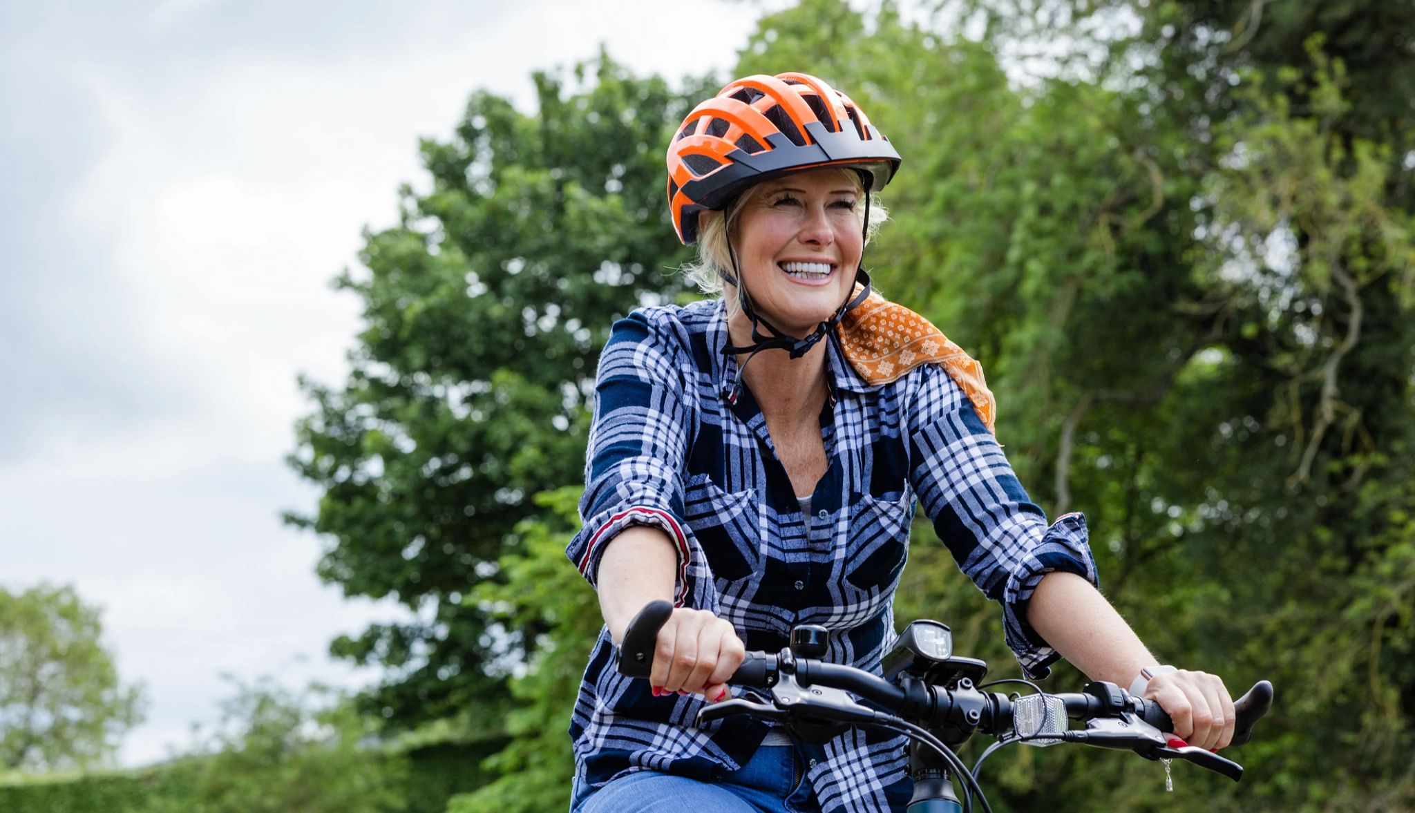 Older woman, wearing helmet, riding a bicycle. Older woman, wearing helmet, riding a bicycle.