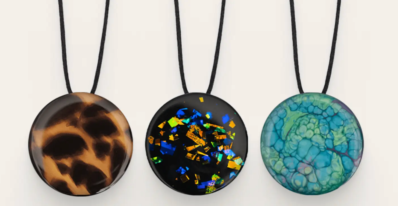 Three charms with different colors hanging from a necklace