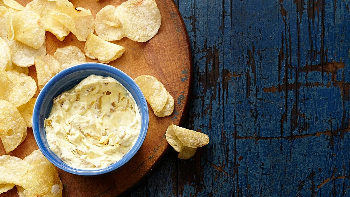 A close-up view of curried onion dip with chips
