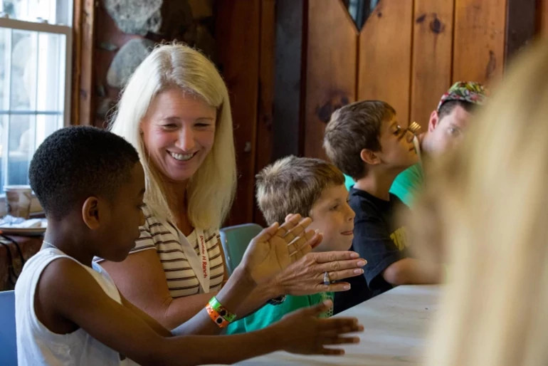 clea newman seated at a table with a group of children