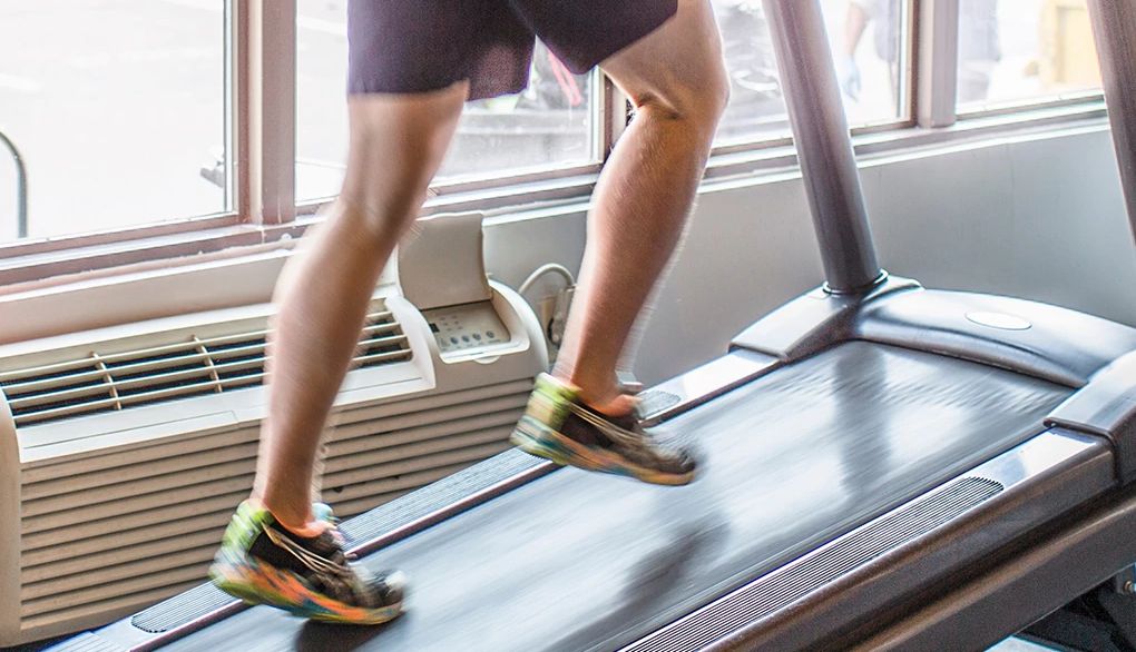 Walking regularly can help improve cardiovascular health The legs of a man walking at an incline on a treadmill