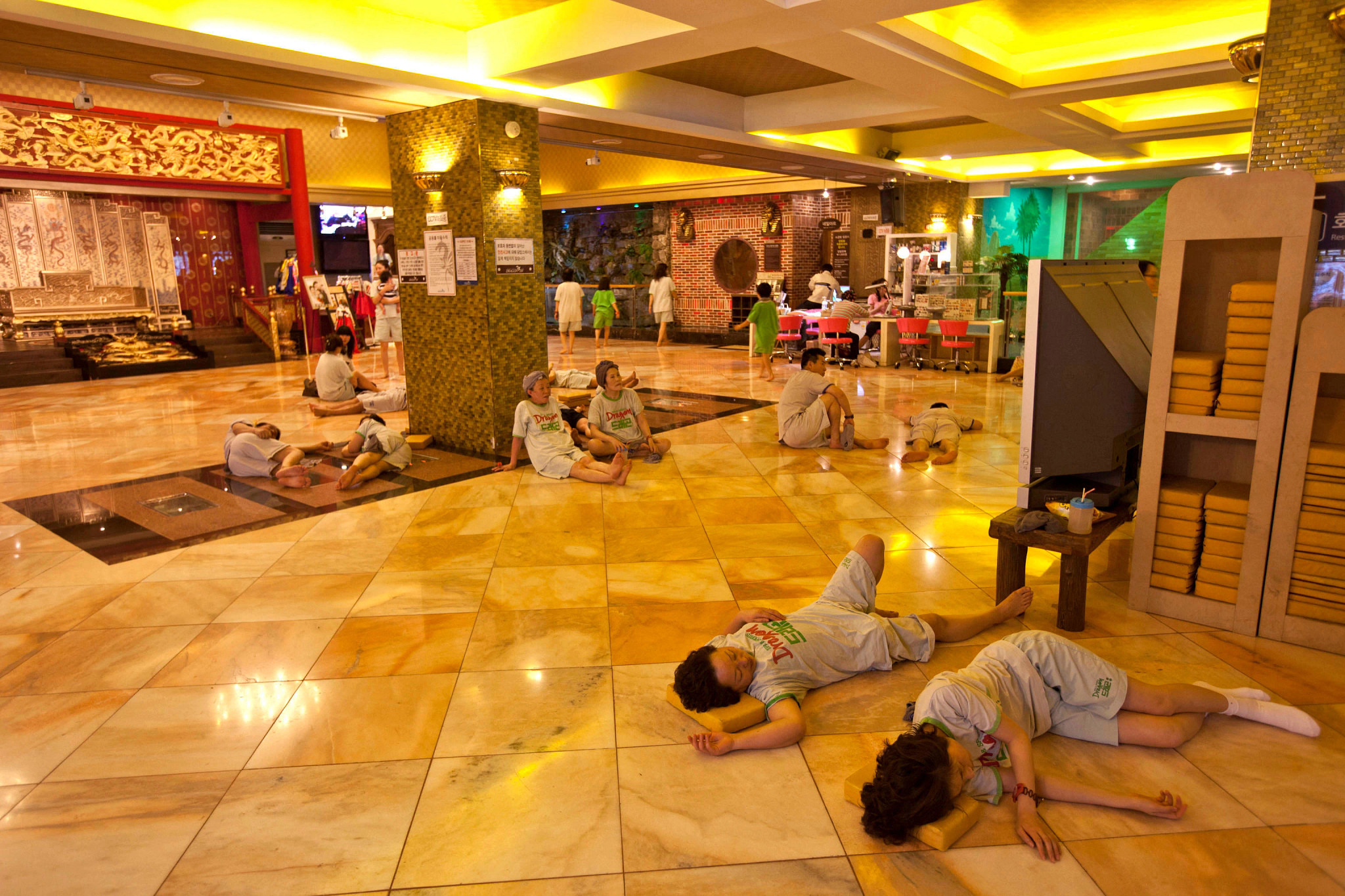 people lounging in a communal relaxation room at a bathhouse in south korea