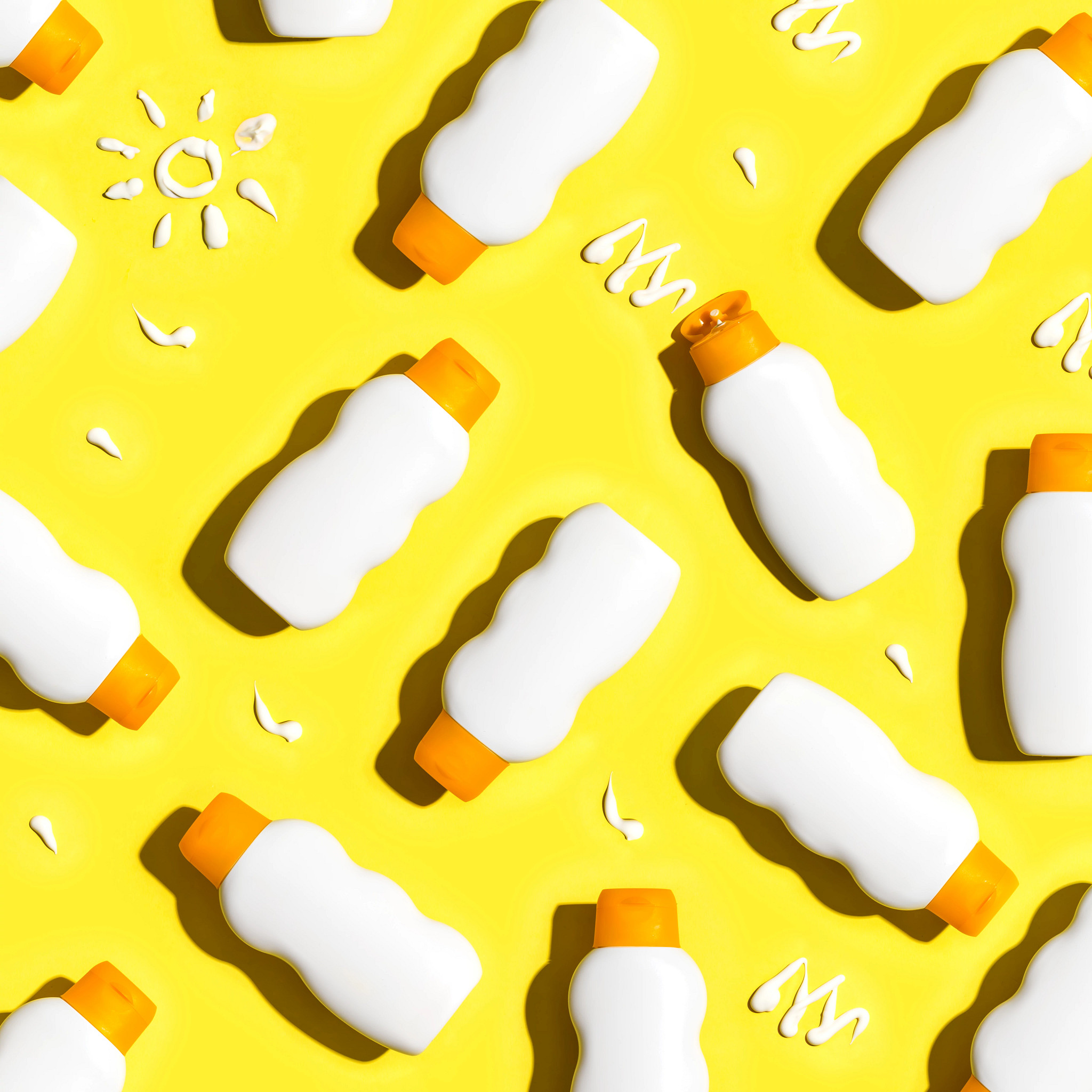 Sunscreen bottles arranged on a bright yellow background