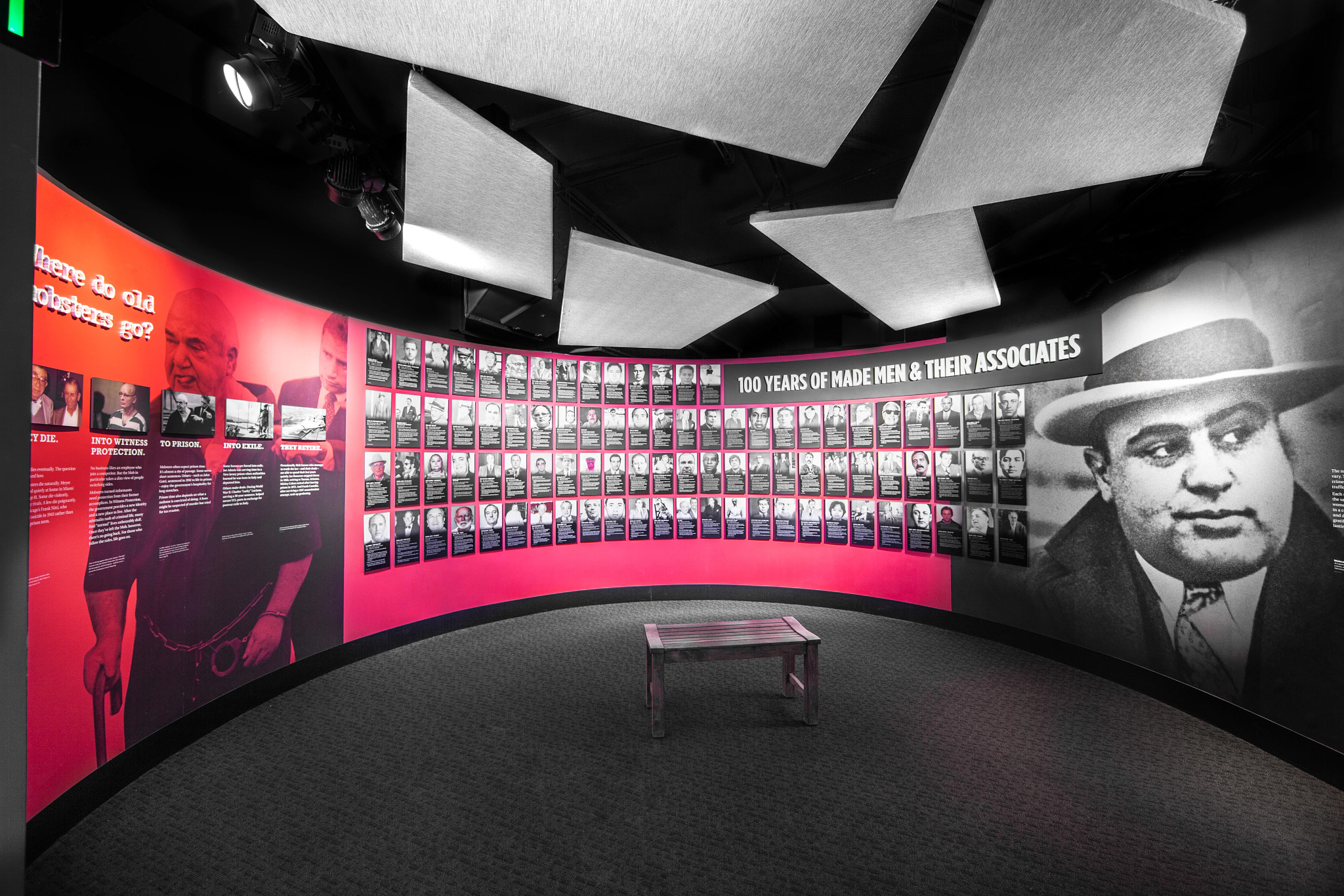 Inside of Mob Museum; curved wall with rows of pictures of people and the words 100 years of made men and their associates