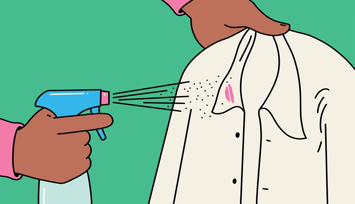 an illustration shows a woman spraying stain remover onto a shirt with a lipstick stain