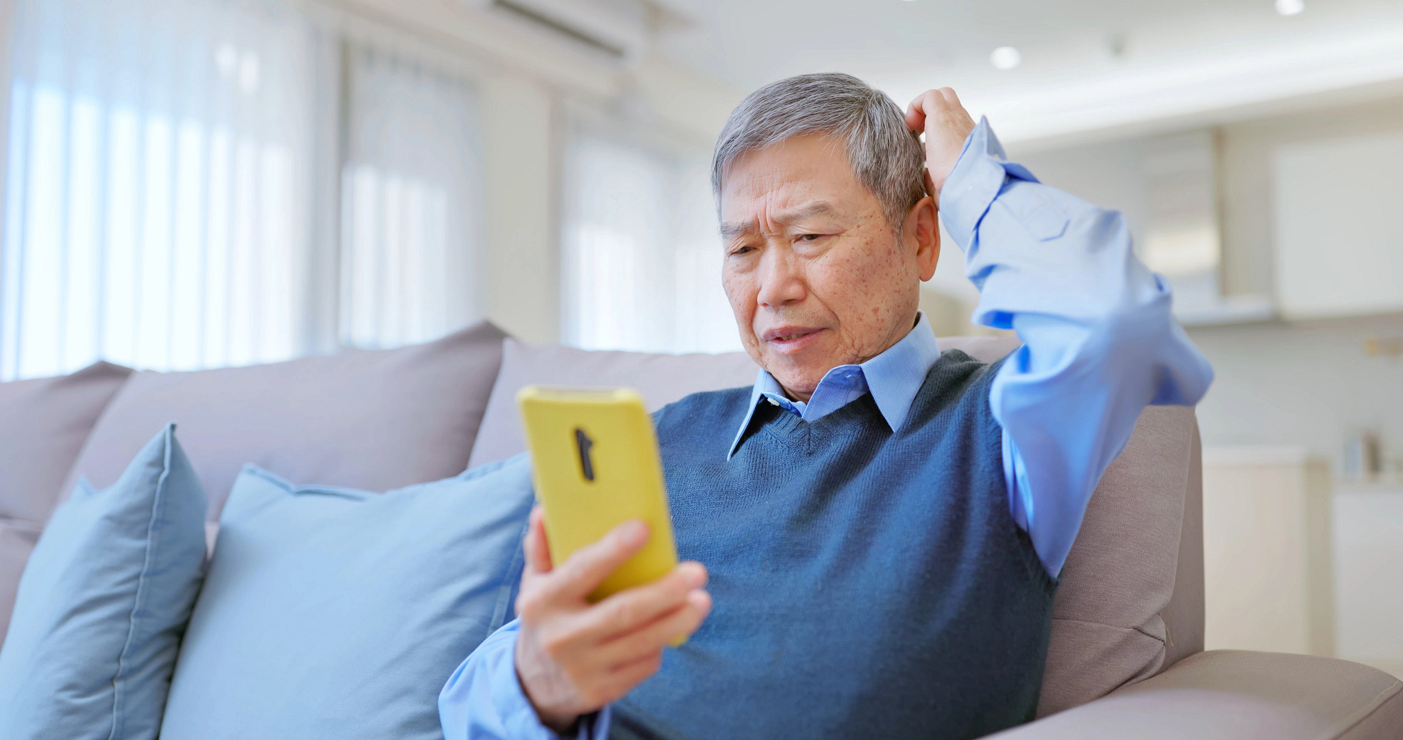 Closeup asian elderly businessman use smartphone at home - he is confused being scammed