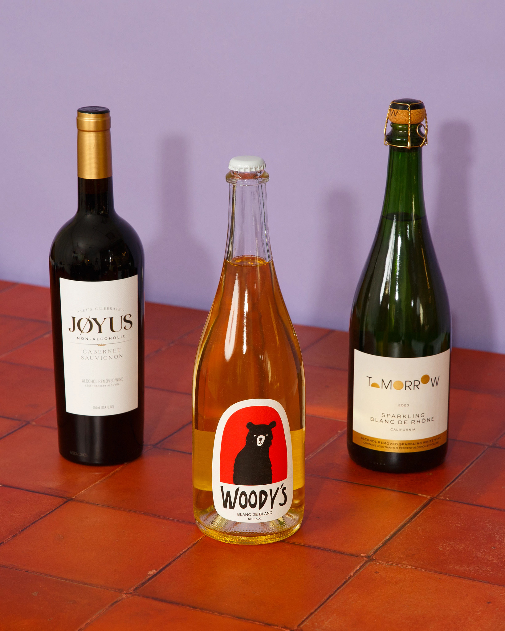 a photo shows, from left to right, Jøyus Non-Alcoholic Cabernet Sauvignon, Woody’s Sparkling Blanc de Blancs Non-Alcoholic Wine and Tomorrow 2024 Rhône Blanc.