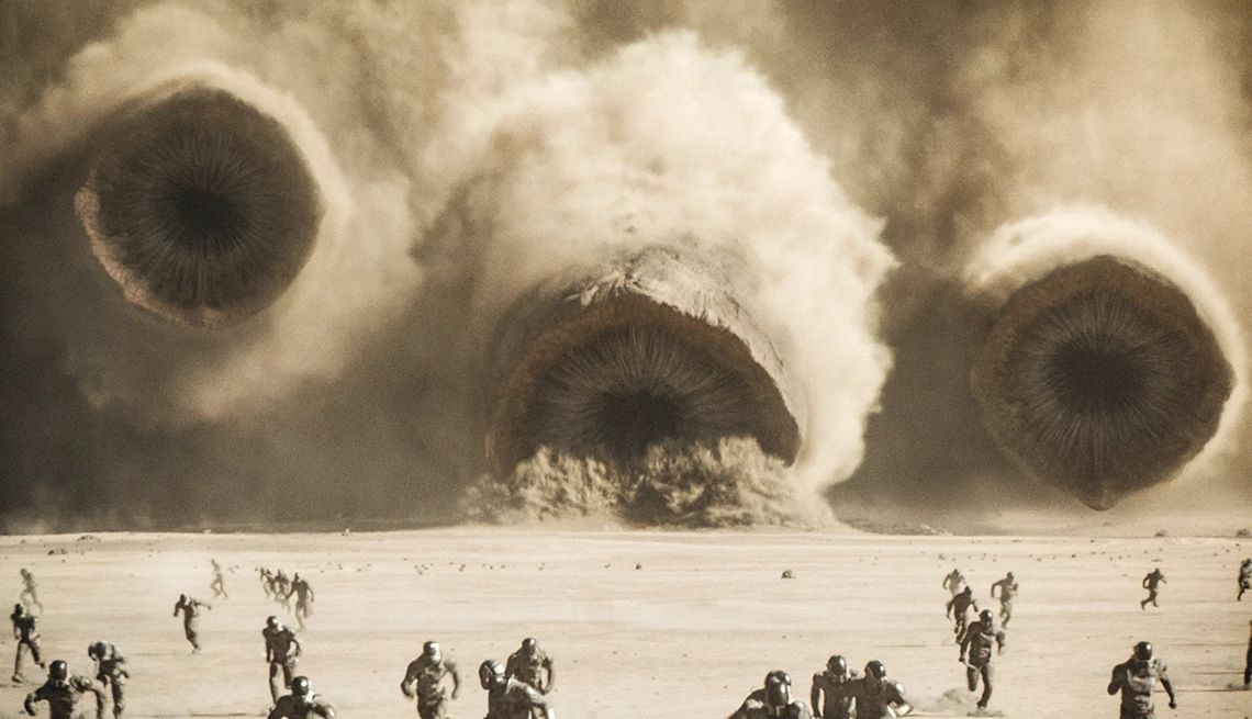 People running away as an aircraft crashes into the desert in "Dune: Part Two."
