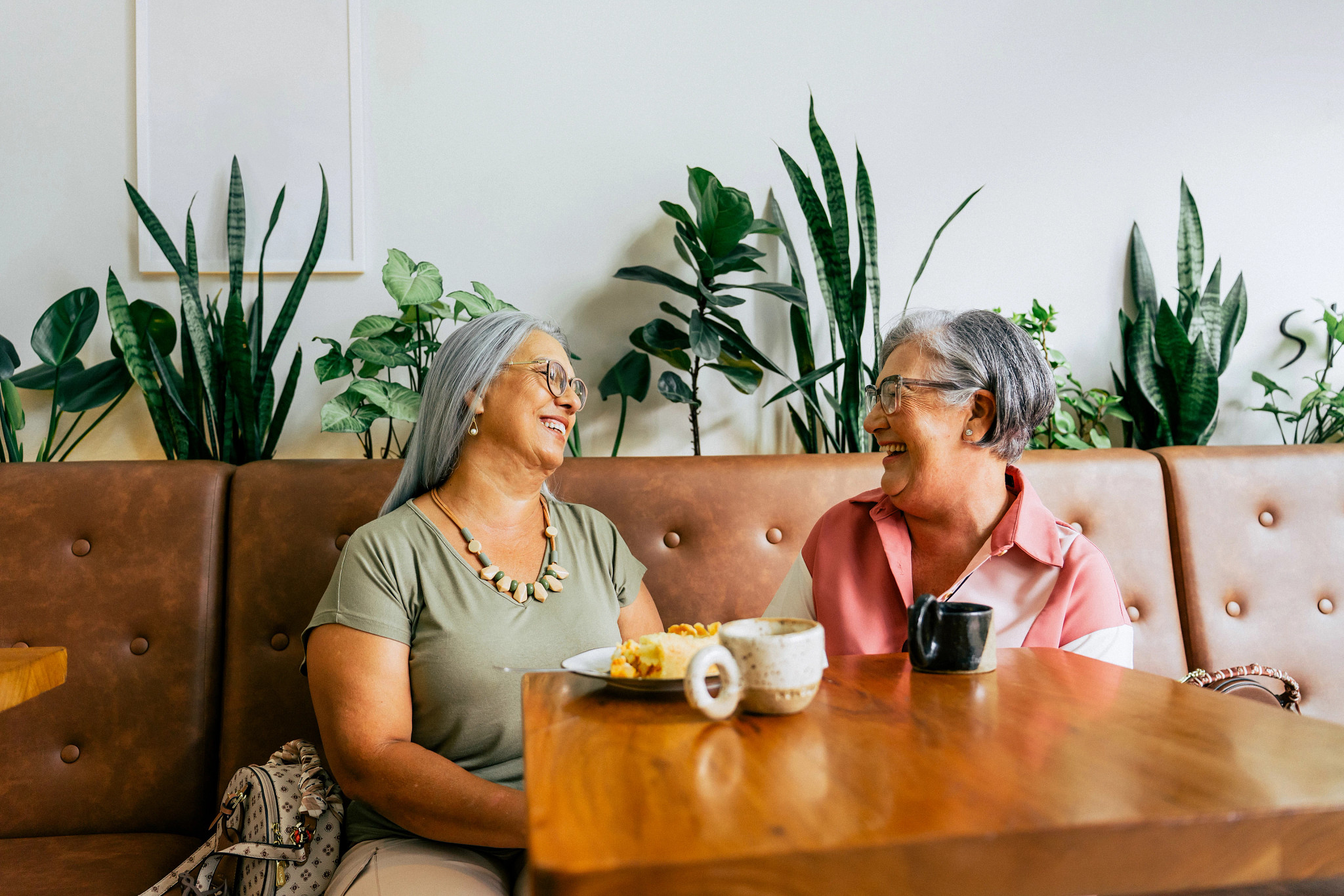 Two female friends chatting while drinking coffee in a cafe