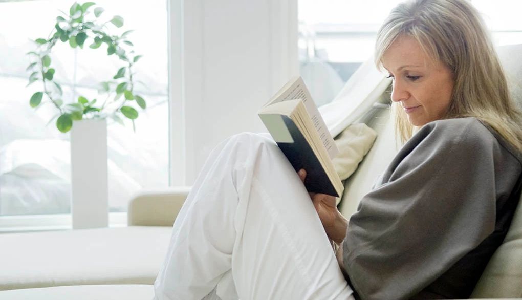 Rereading books may benefit brain health A woman reading a book on a couch