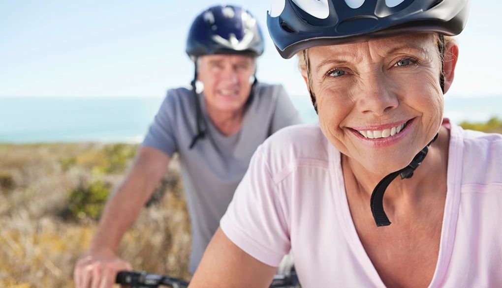 Aerobic exercise is important for overall health, including brain health A man and woman smiling together on bicycles