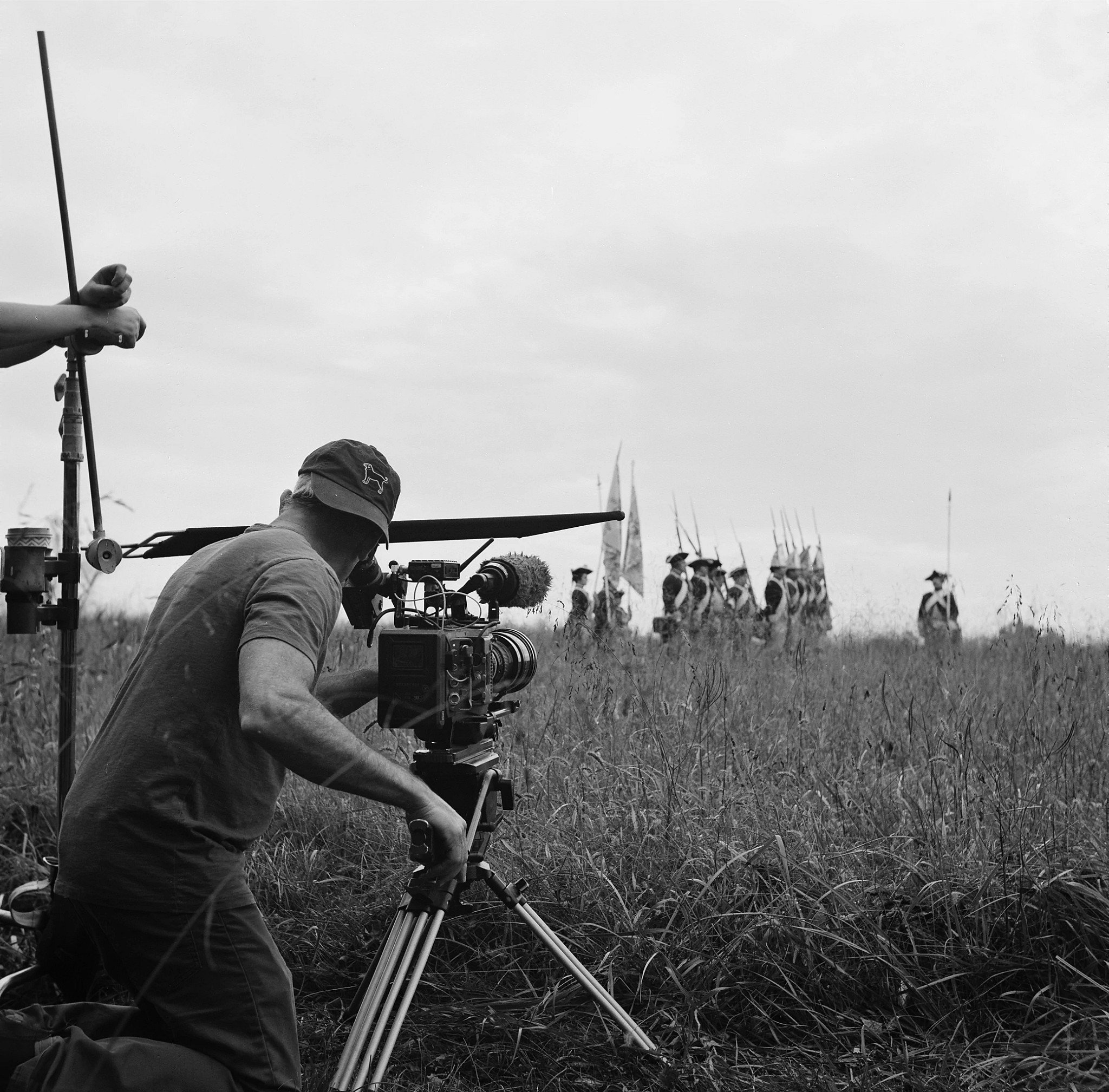 a cinematographer filming a reenactment of soldiers in the american revolution