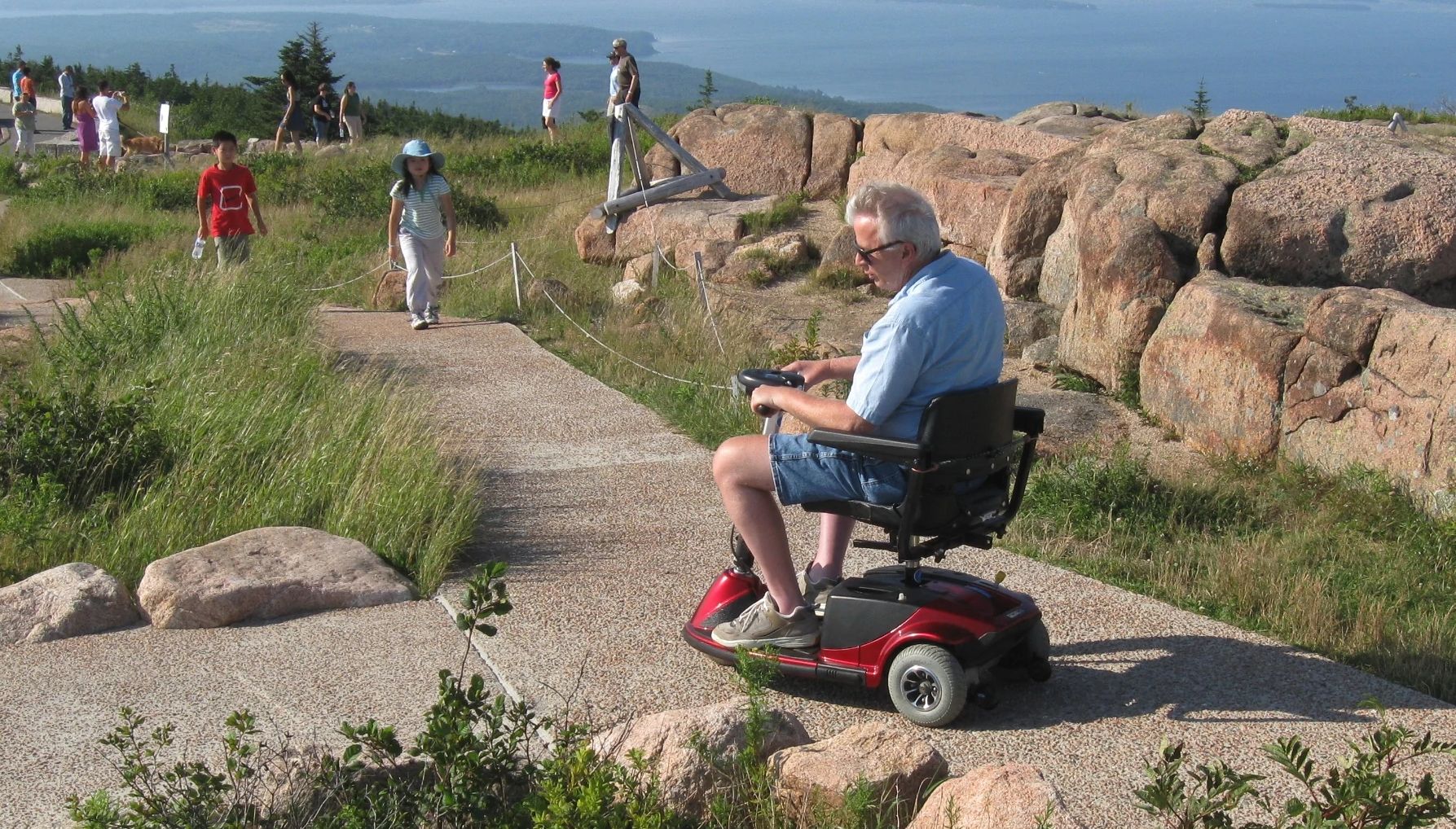 Un hombre en silla de ruedas a lo largo del sendero accesible de Cadillac en el Parque Nacional Acadia