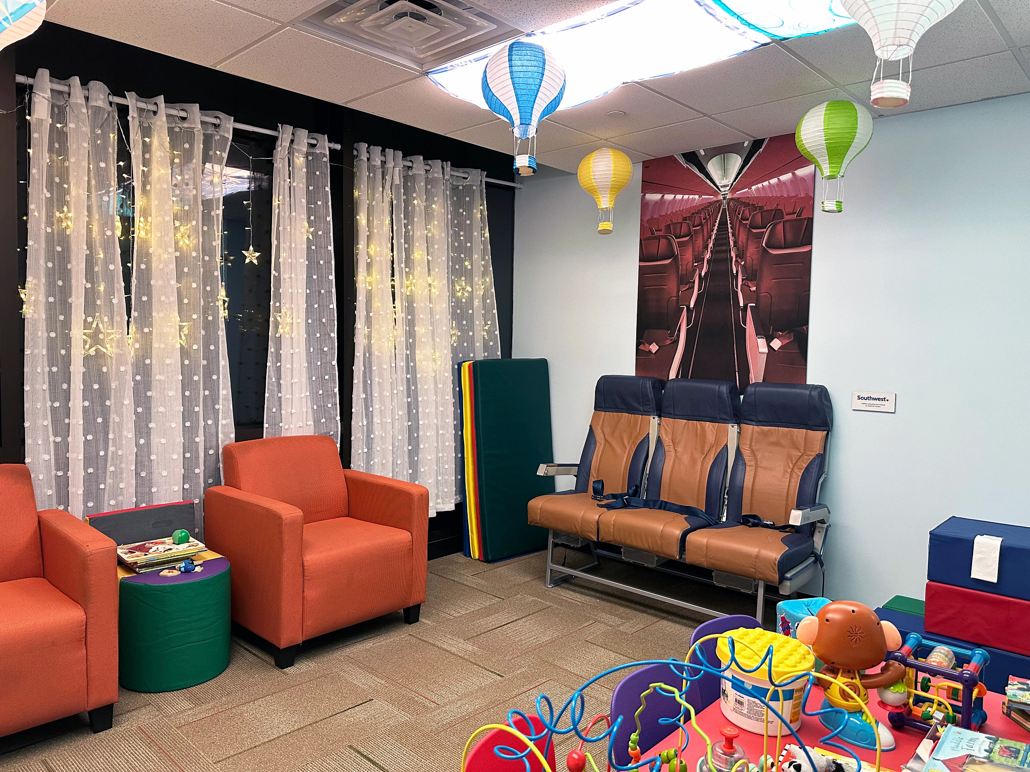 a room with toys, chairs and airplane-related items