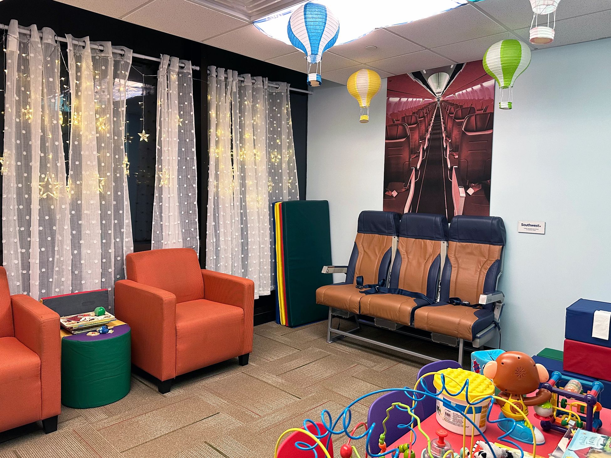 Compassion Corner a room with toys, chairs and airplane-related items
