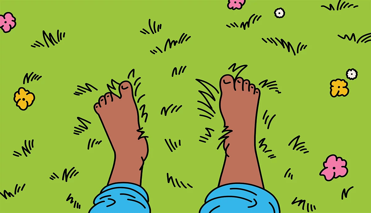 A person walking barefoot through flower-petal strown grass