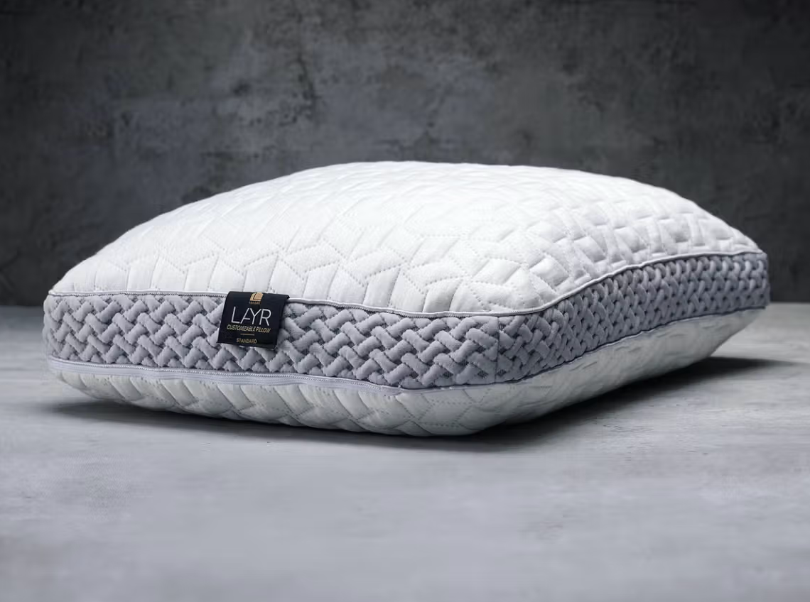 The Luxome LAYR Pillow lying flat on a gray background