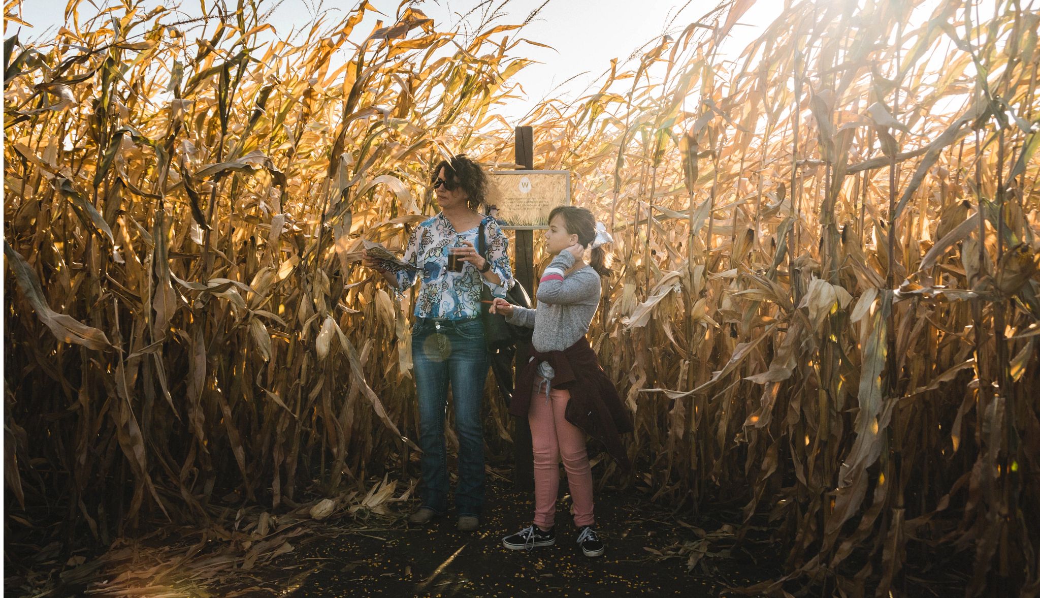 Colorful Fall Fests a woman and child standing in a corn maze