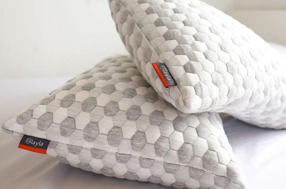Two Layla Kapok Pillows stacked on a bed