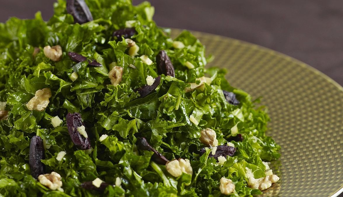 Kale salad with preserved lemon and walnuts A close-up view of kale salad with preserved lemon and walnuts