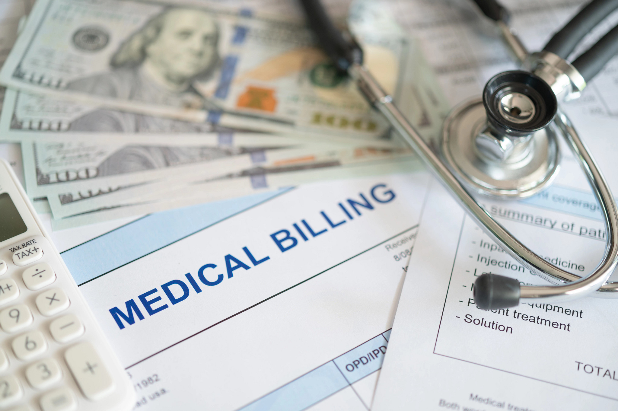 medical billing document and dollar banknote, calculator, stethoscope. medical treatment expense concept