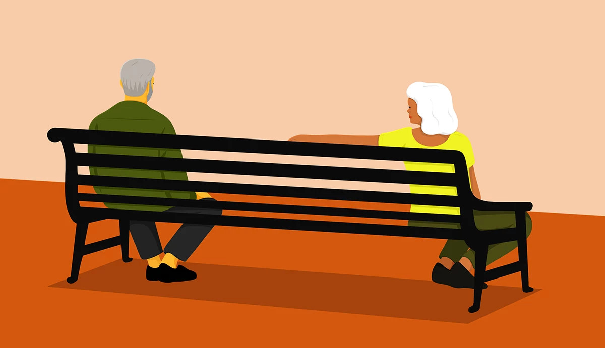an illustration shows from a rear viewpoint an older adult couple sitting on different ends of a park bench. The woman’s arm is trying to bridge the divide but the husband isn’t interested