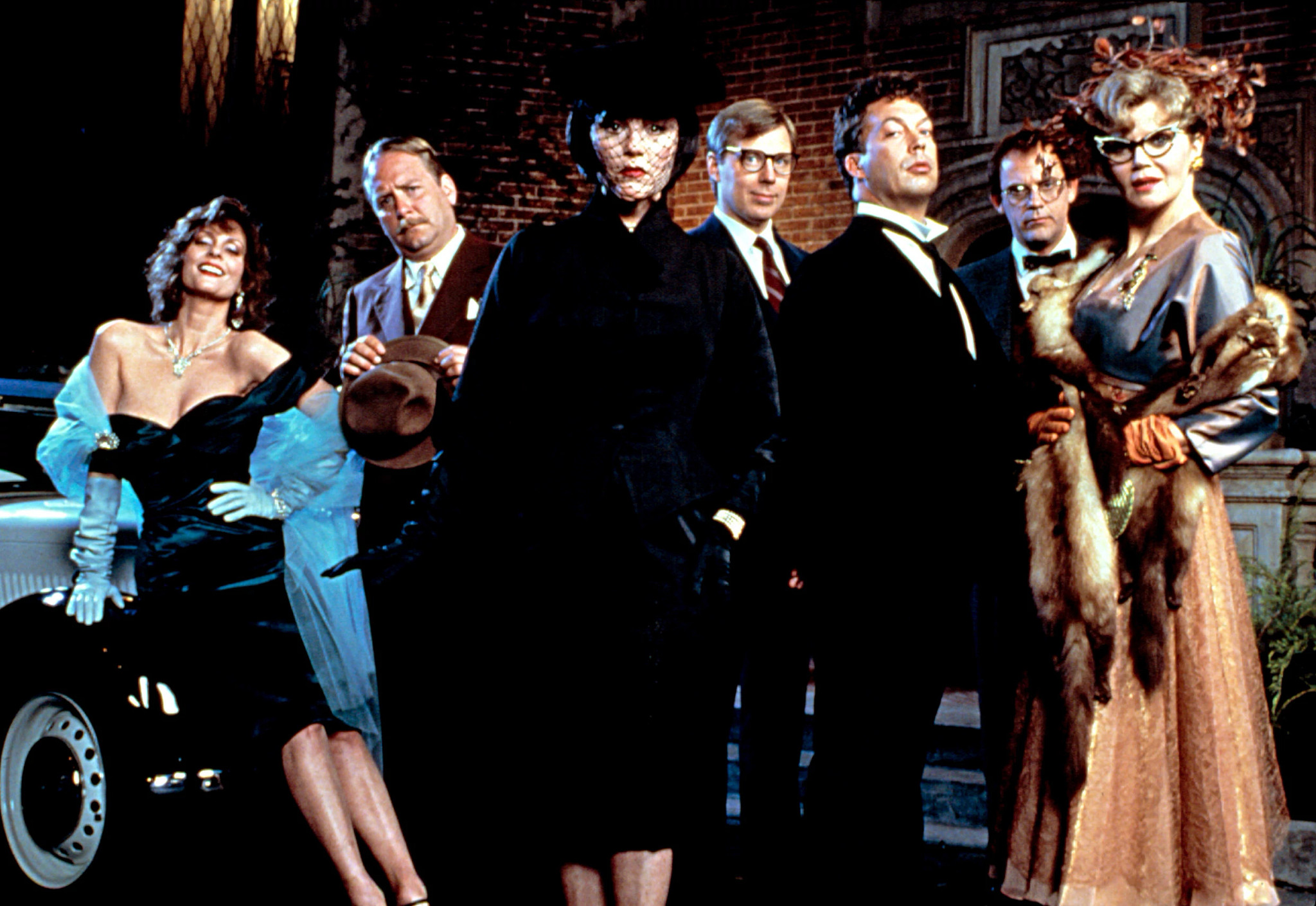 tim curry in costume with the cast of clue