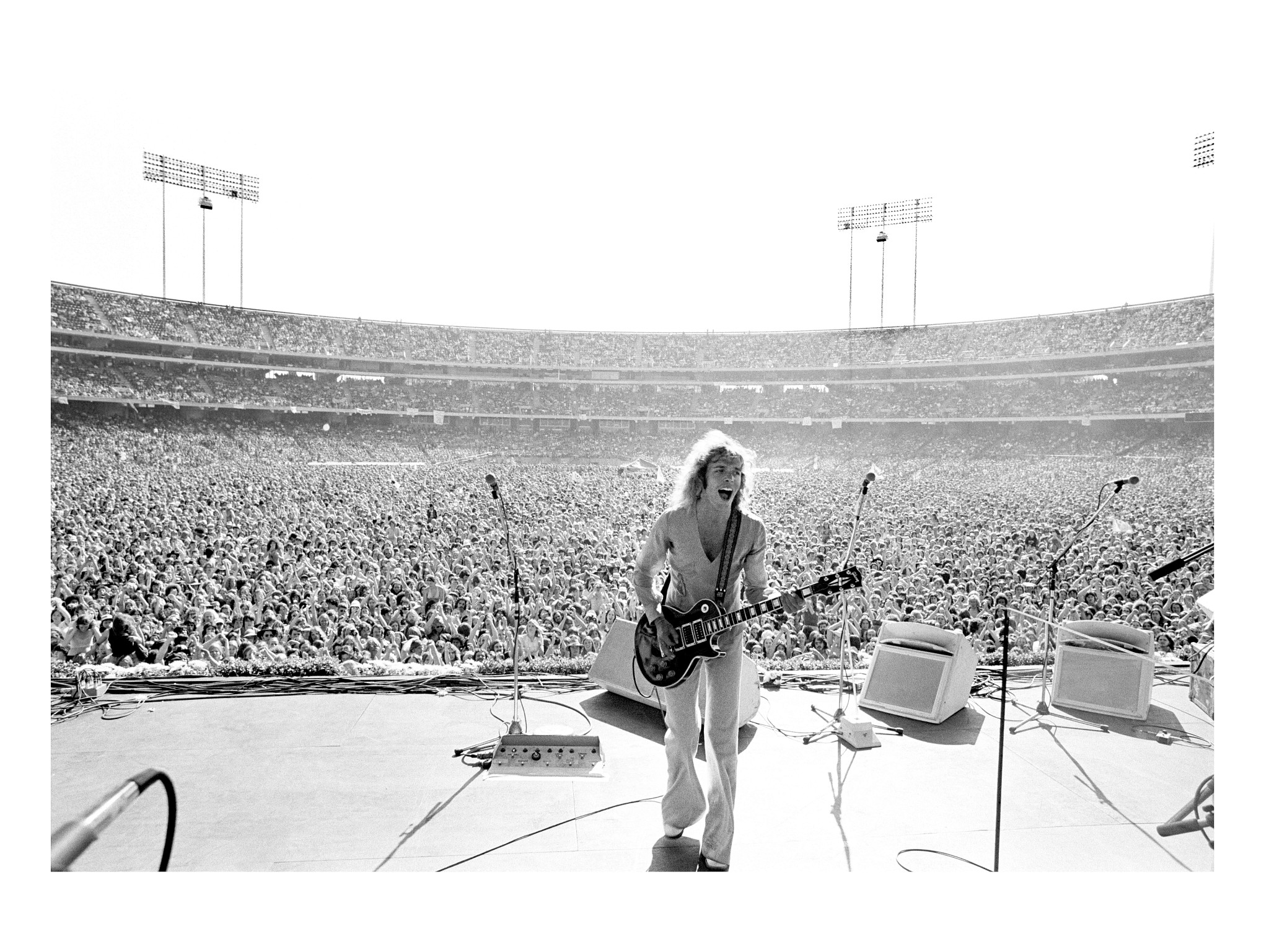 peter frampton performing at a stadium concert in 1977