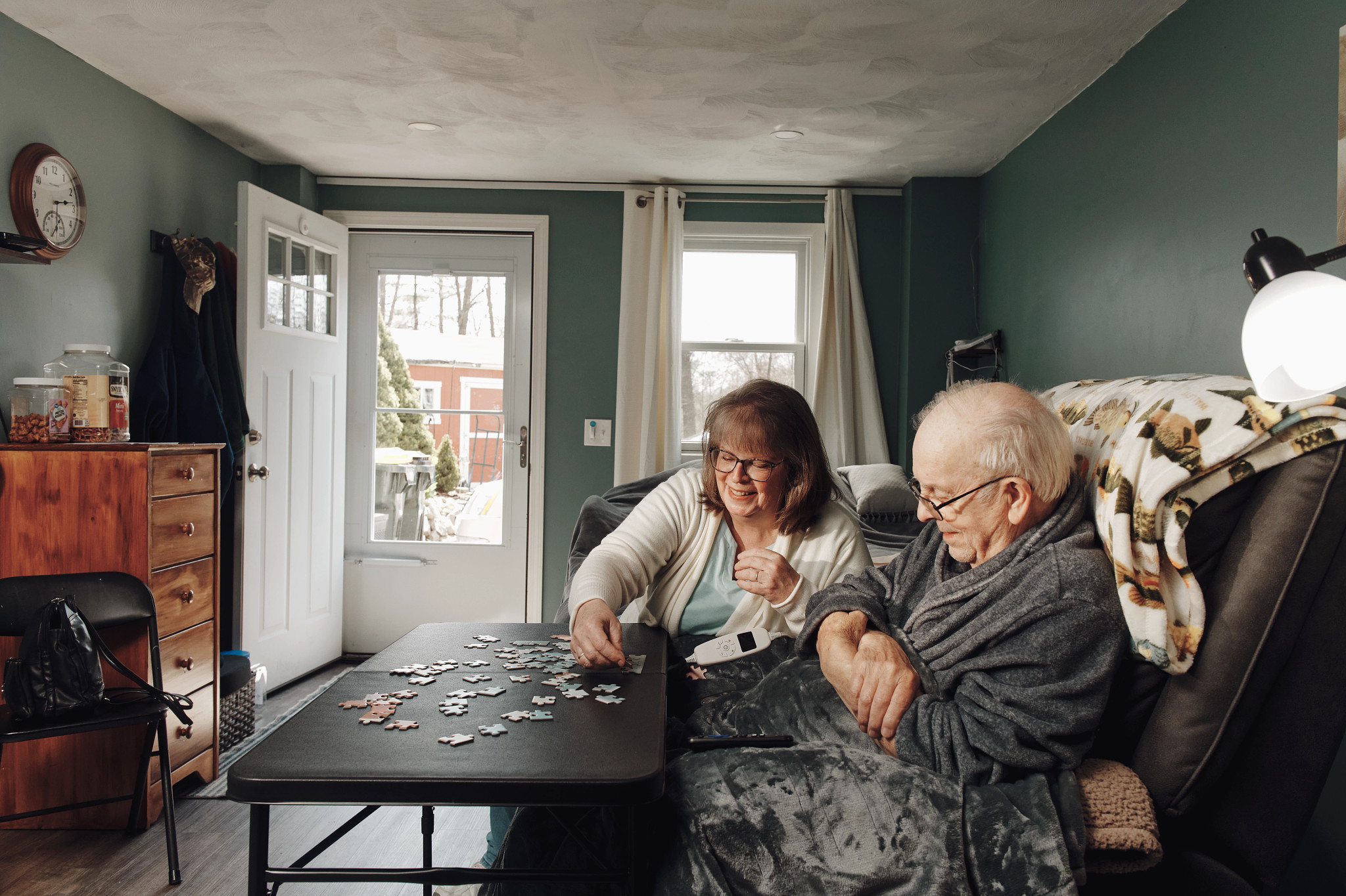 two people put together a puzzle in their home