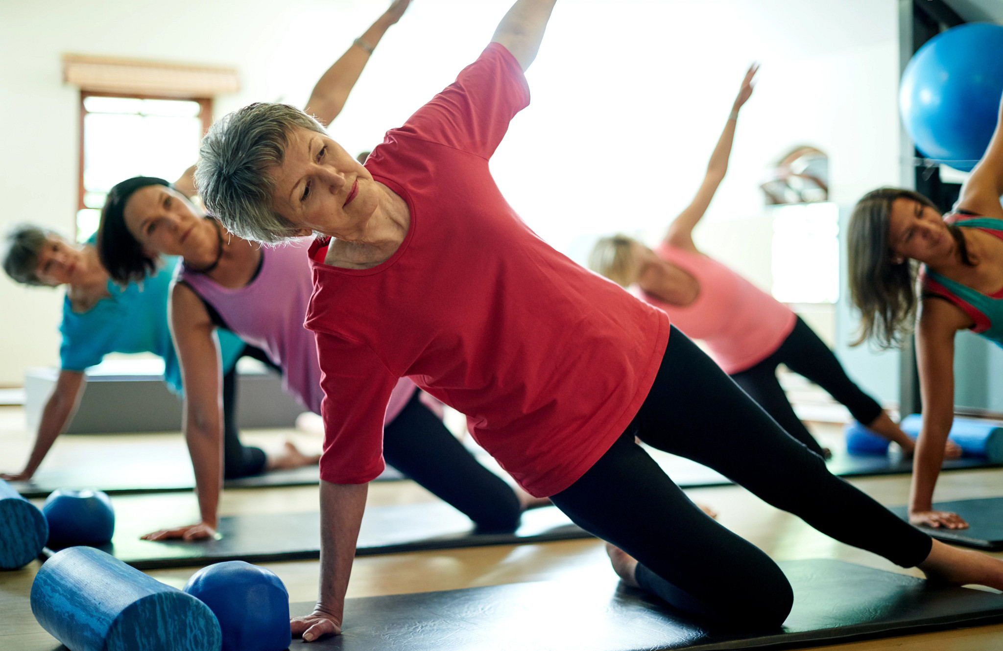 a woman in a Pilates class in a modified side plank pose