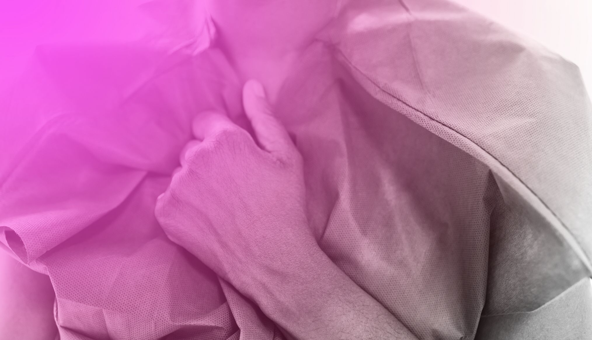 Breast Cancer Signs woman holding her hospital gown with pink overlay