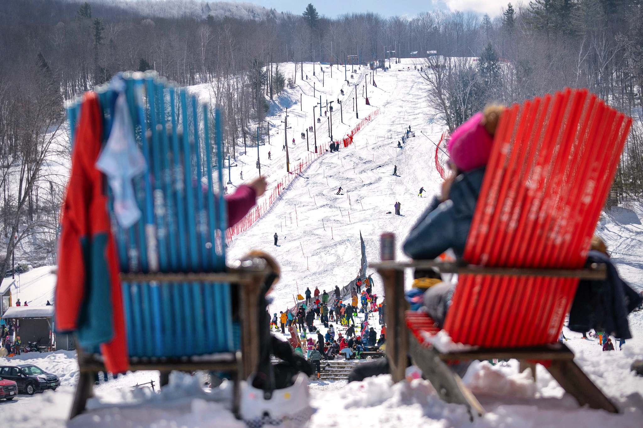 people sitting in chairs with a ski resort in the background