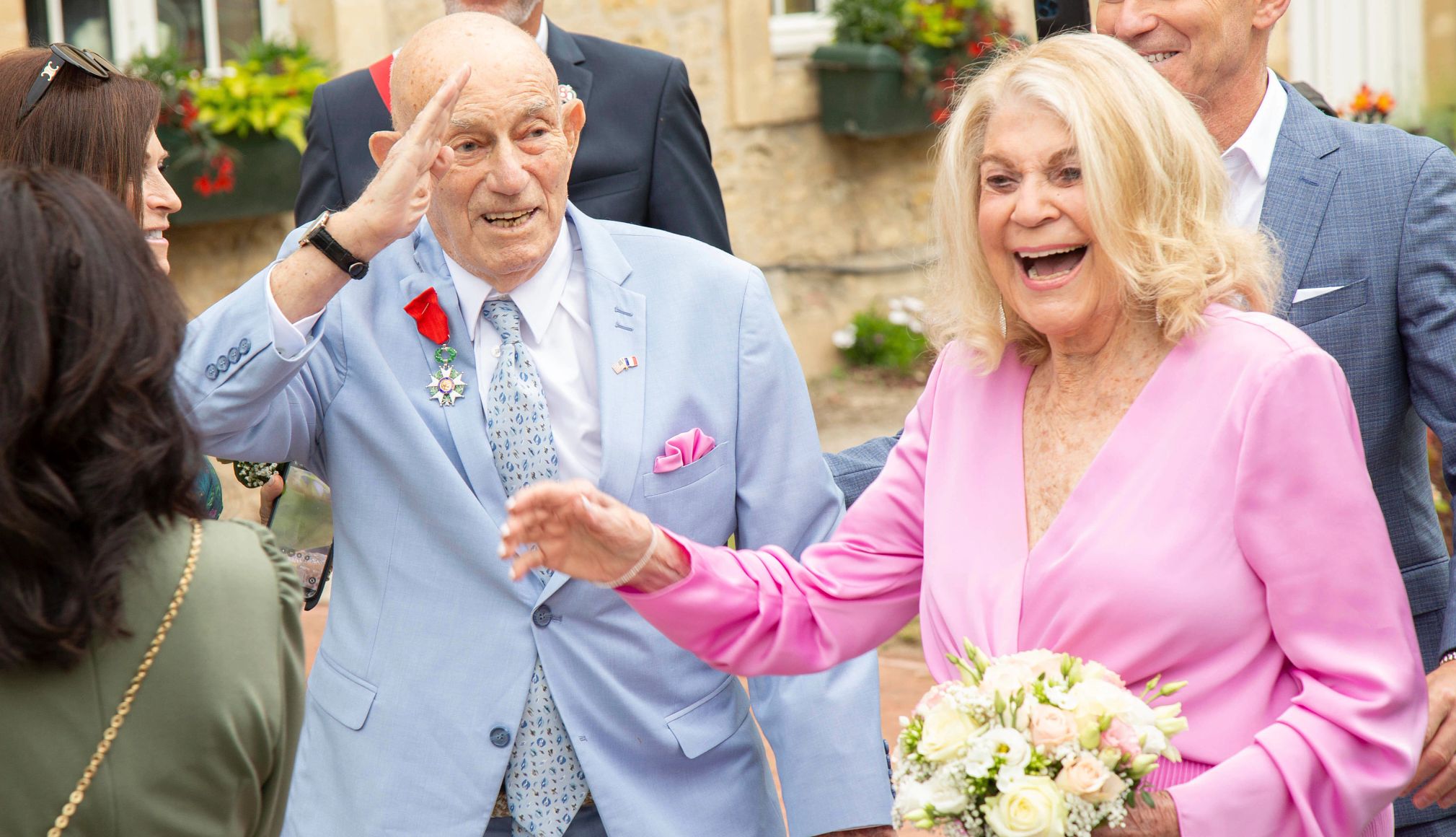 World War II veteran Harold Terens marries Jeanne Swerlin harold terens, in a light blue suit, stands behind jeanne swerlin, holding flowers in a light pink dress. both are smiling during their wedding.