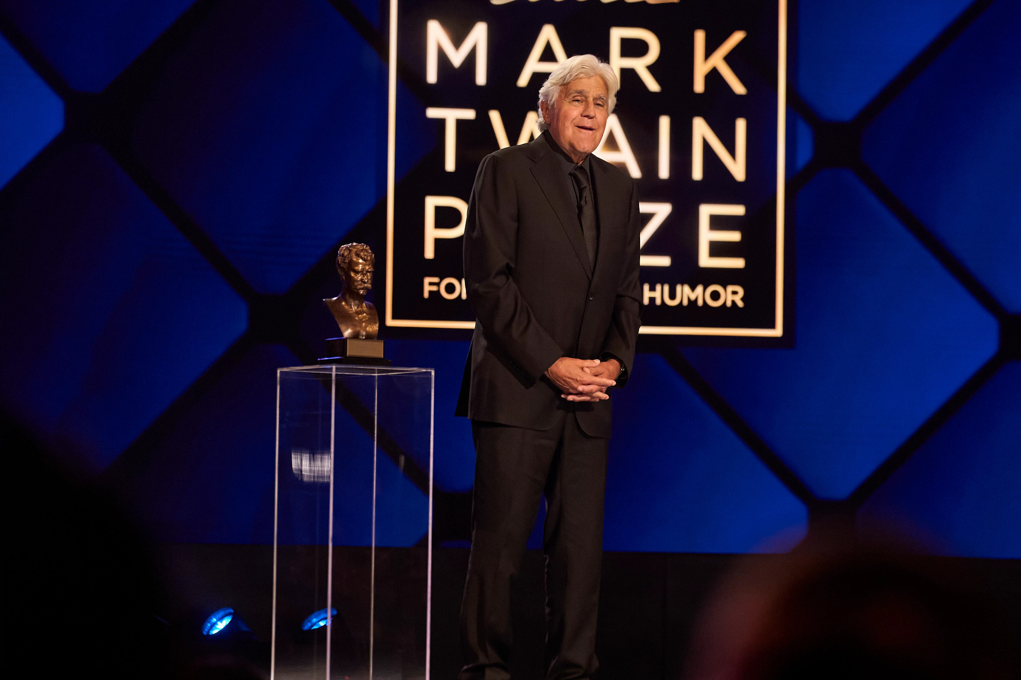jay leno speaking onstage at the mark twain prize award ceremony