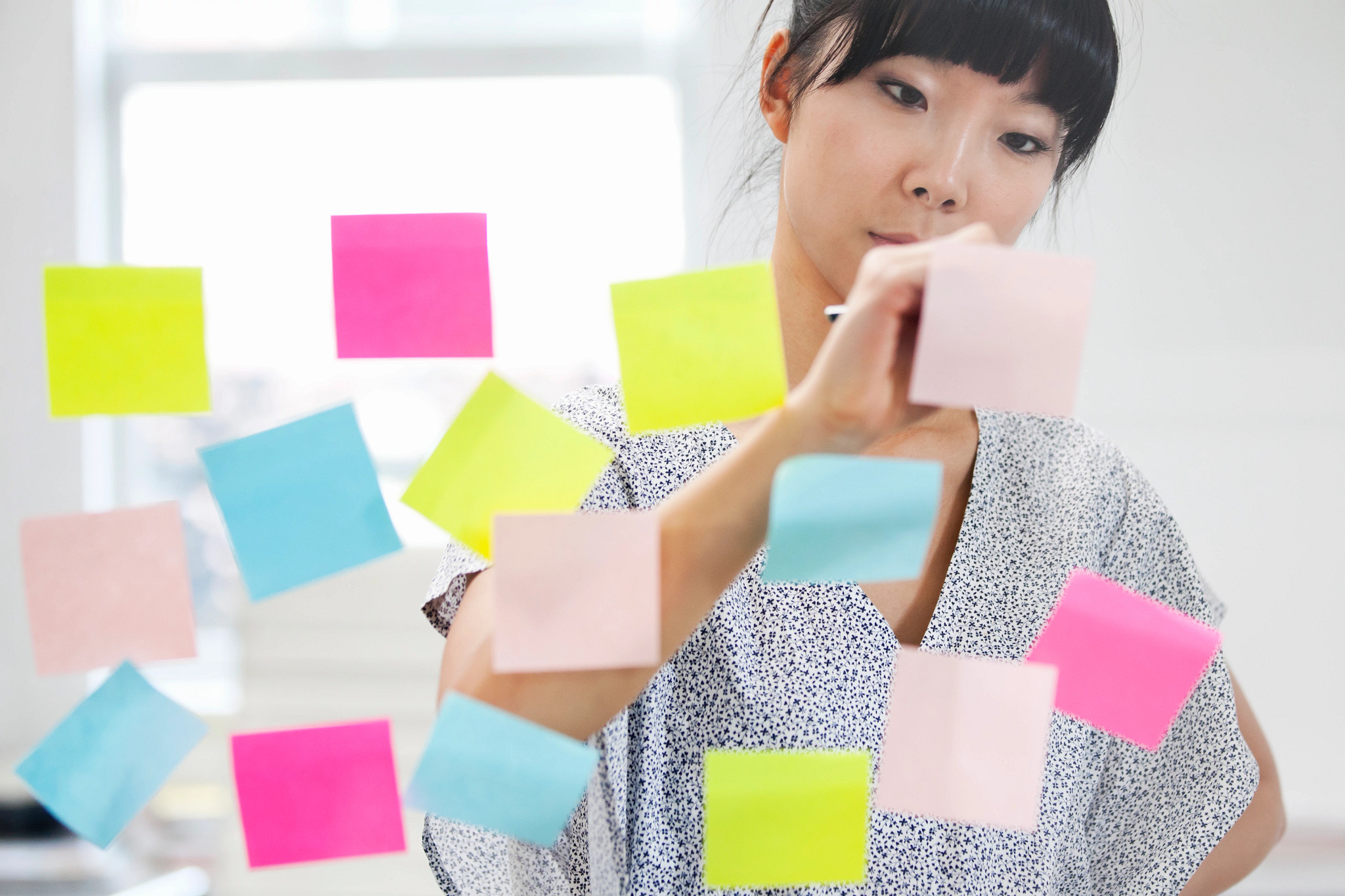 Woman crossing off colorful post-its