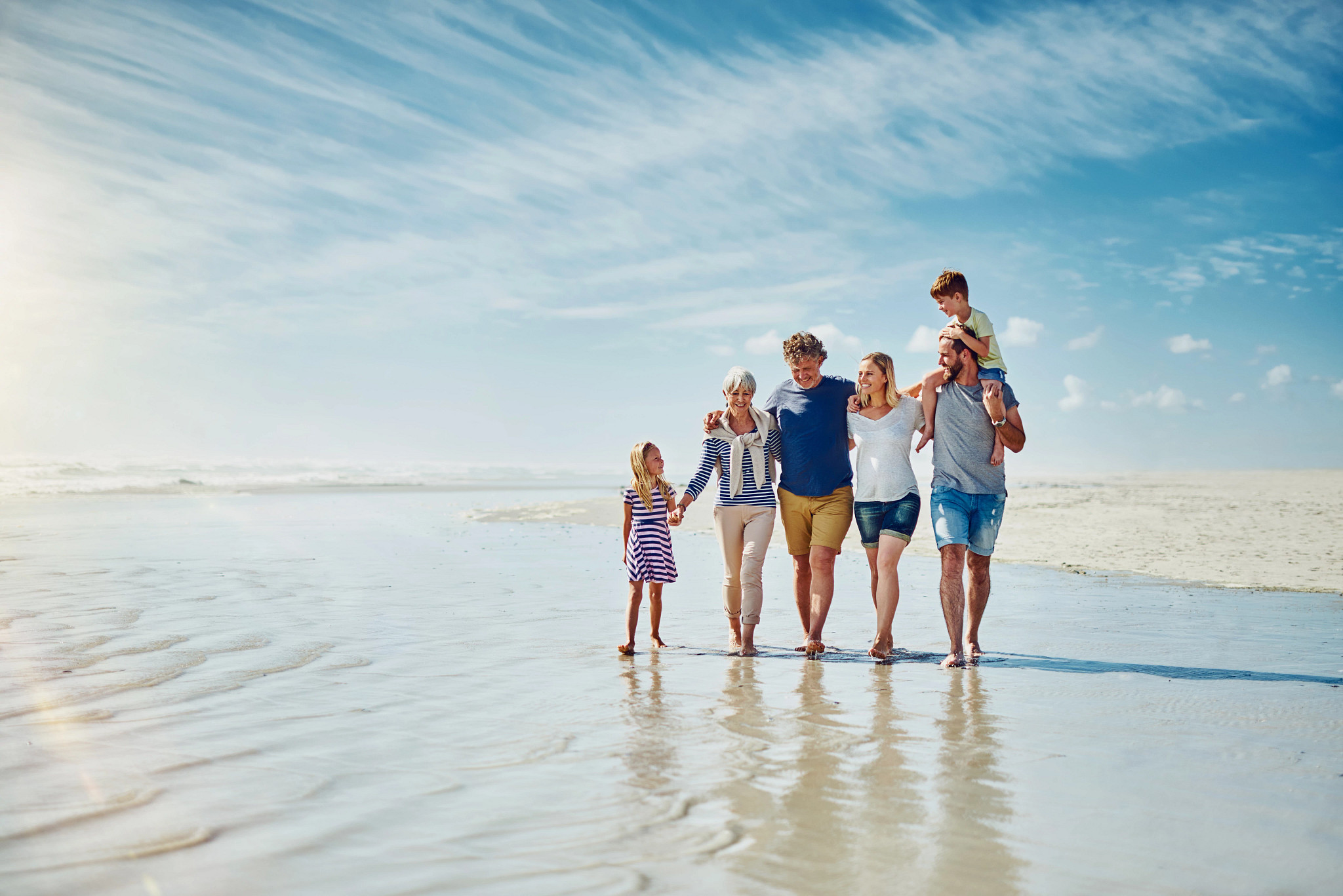 Multigenerational family walking on the beach