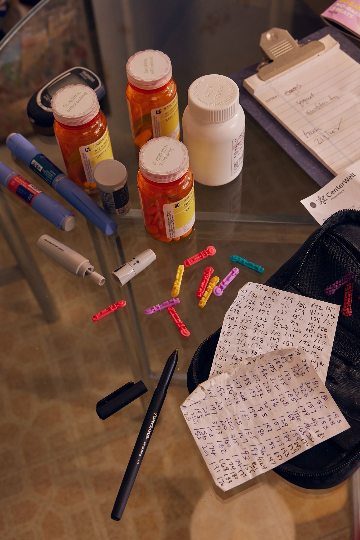 Prescription drug costs pill bottles and a handwritten list of numbers
