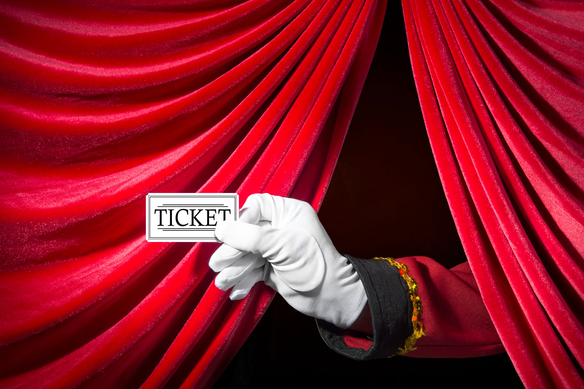 Usher's hand holds a theater ticket with red curtain behind.