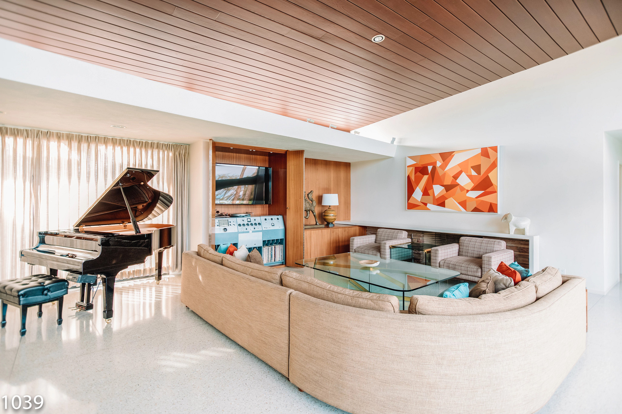 a living room with a piano and mid-century decor