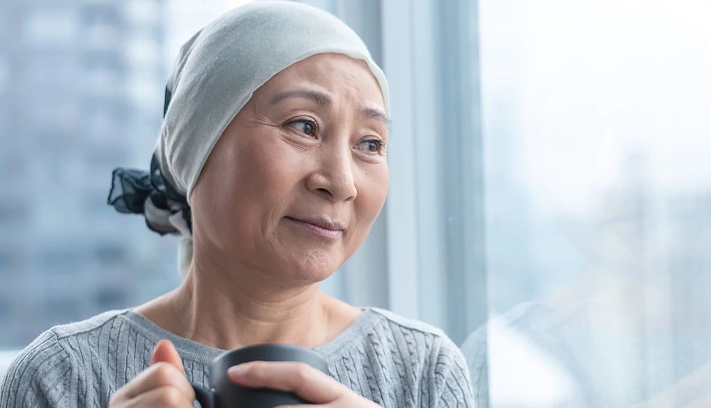 Bring awareness to the presence of pain or difficulty in your body A woman by a window with a mug in her hands