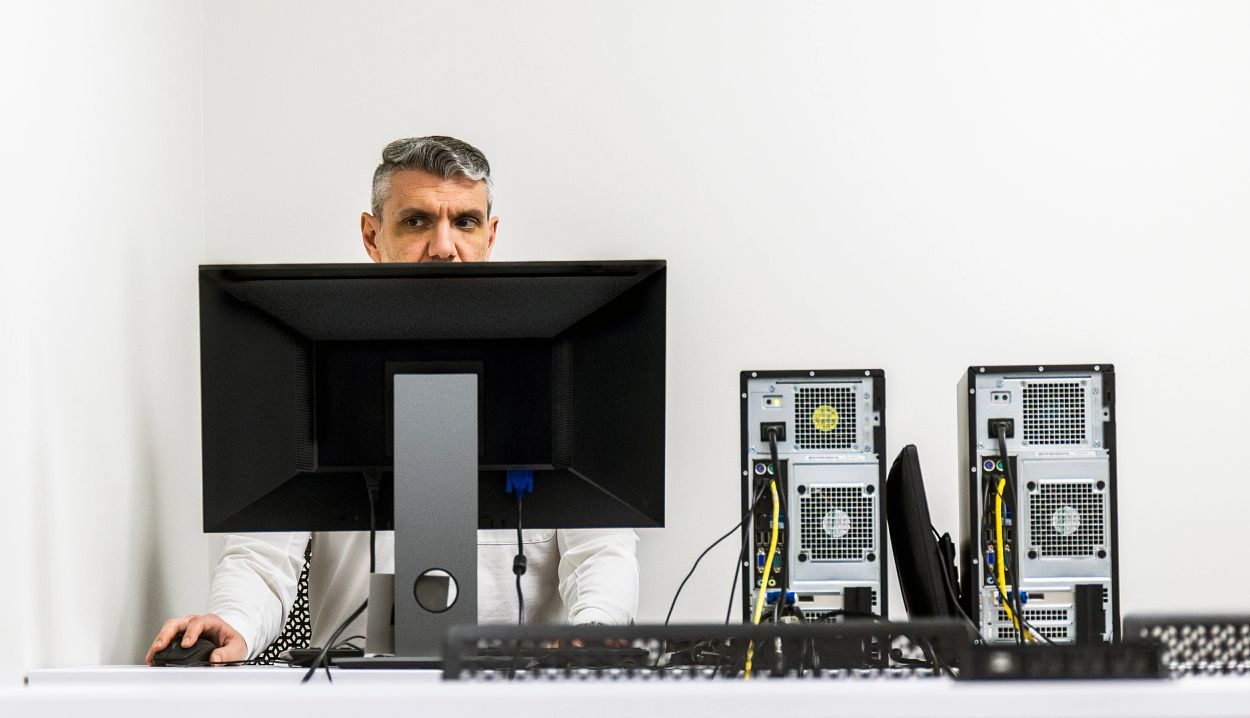 un hombre trabajando en su escritorio con su computadora