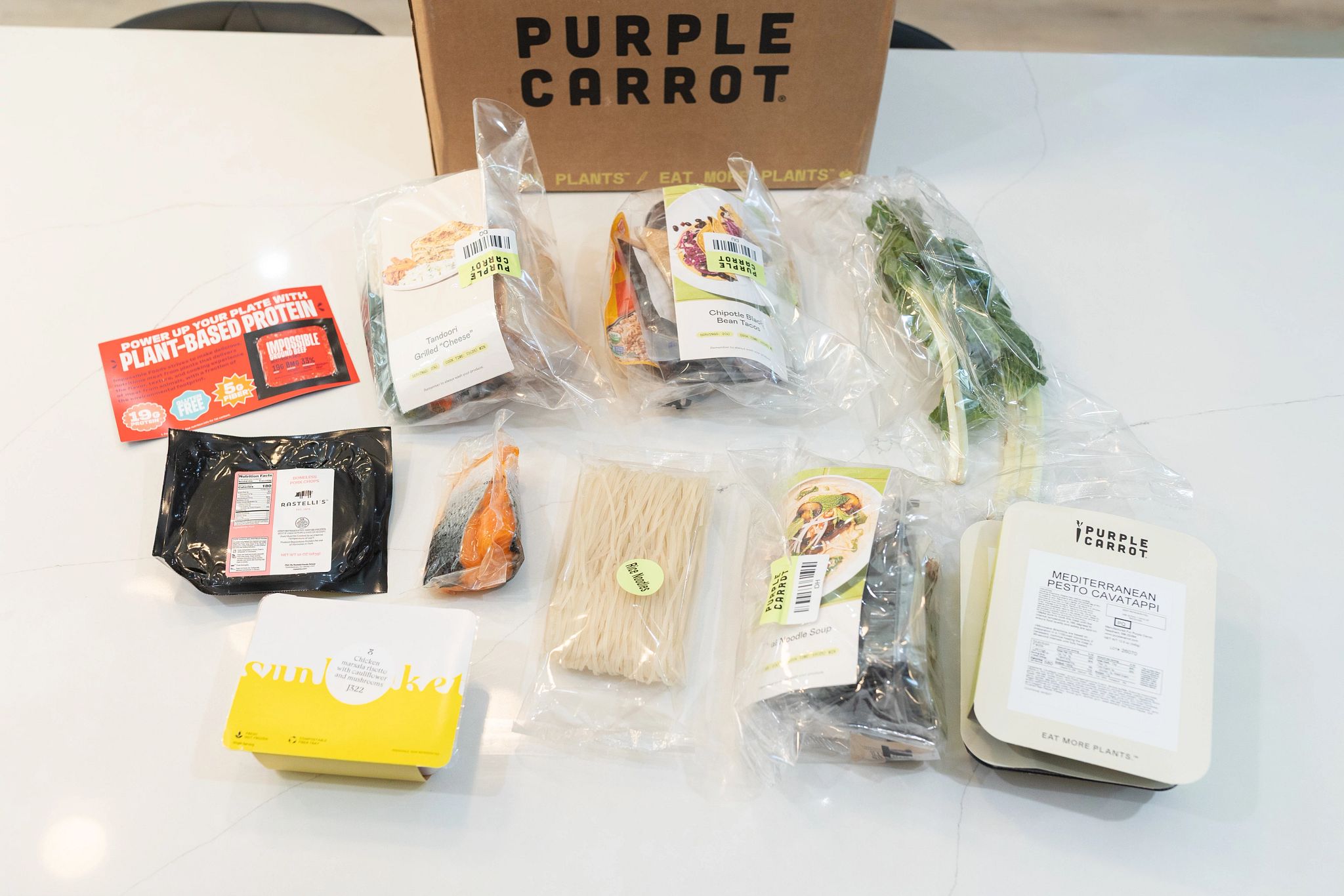 An unpacked Purple Carrot meal kit on a counter.