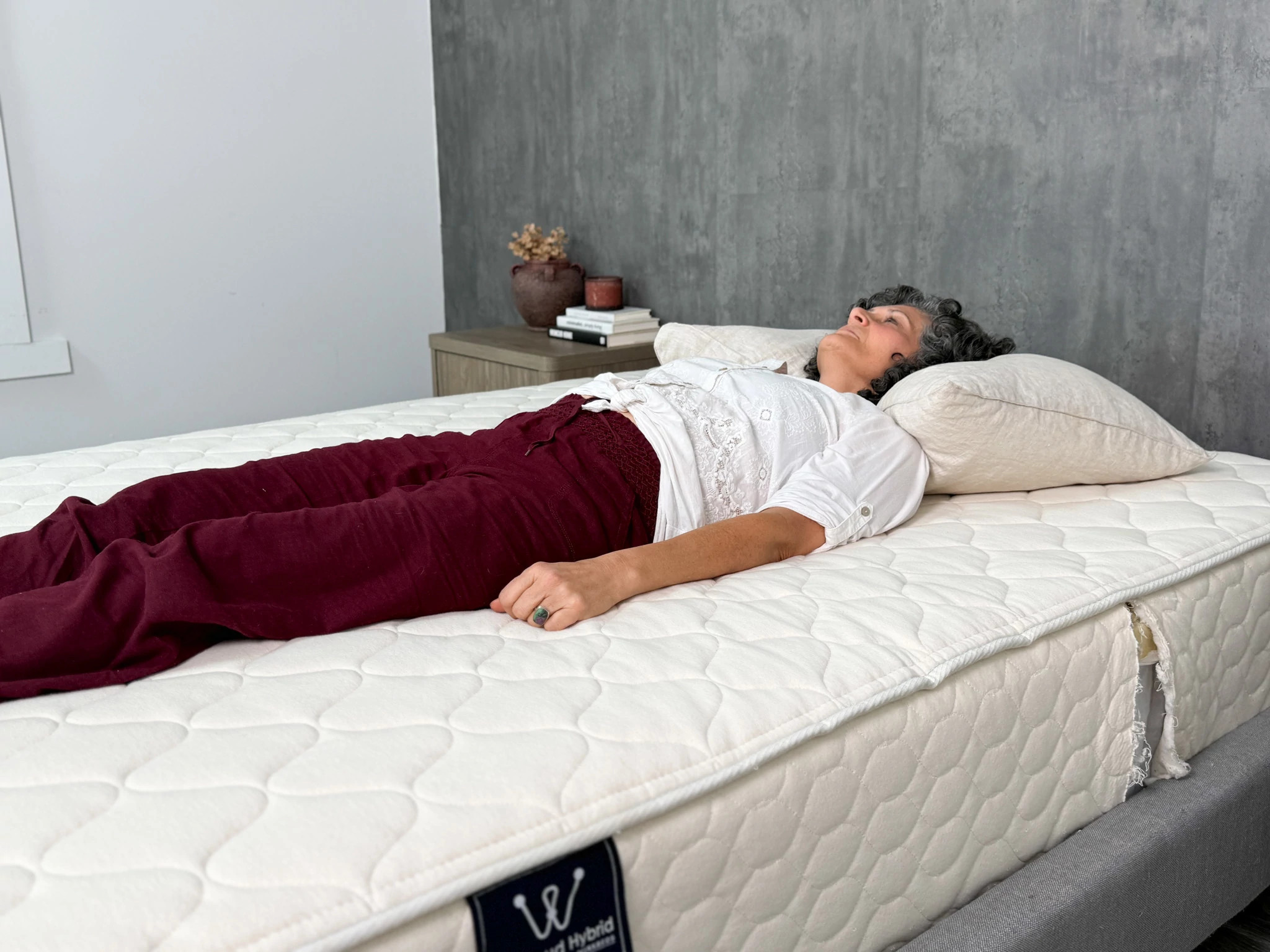 A woman lies on her back while sleeping on the WinkBeds EcoCloud mattress.