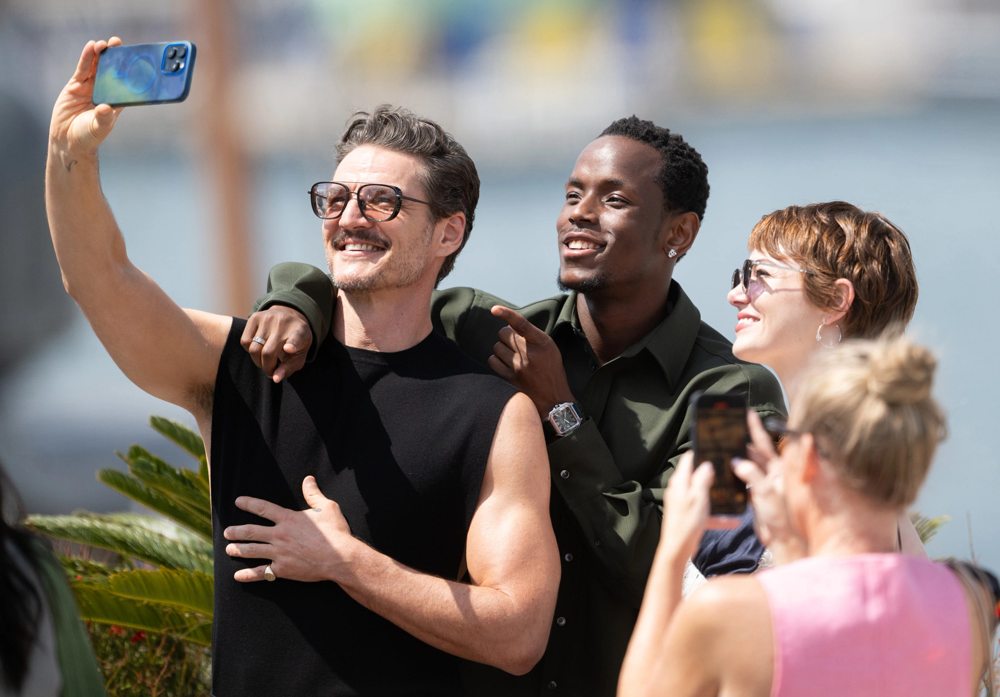 Pedro Pascal is shown in a photo taking a selfie with fans.