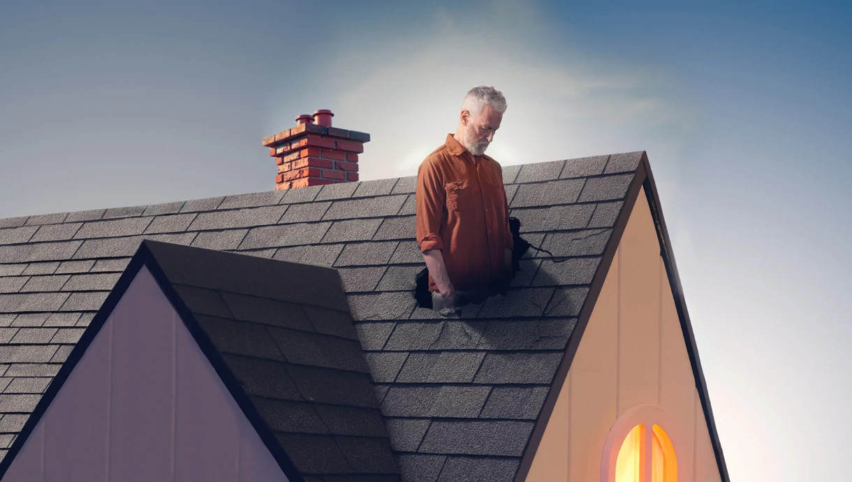 a forlorn looking man stands in a hole in the roof of his home